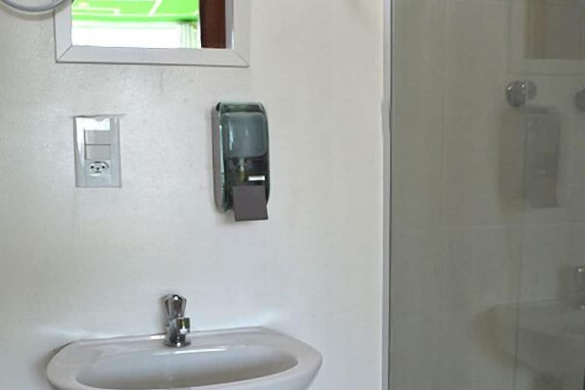 Een douche, handdoeken, zeep, shampoo