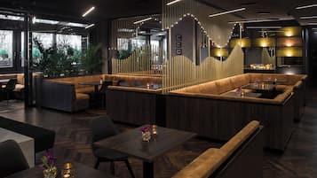Un interior moderno con zonas de estar, paneles de madera e iluminación ambiental.