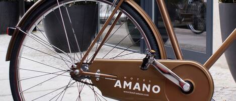 Un vélo avec un cadre marron et un logo sur lequel on peut lire « AMANO HOTEL ».