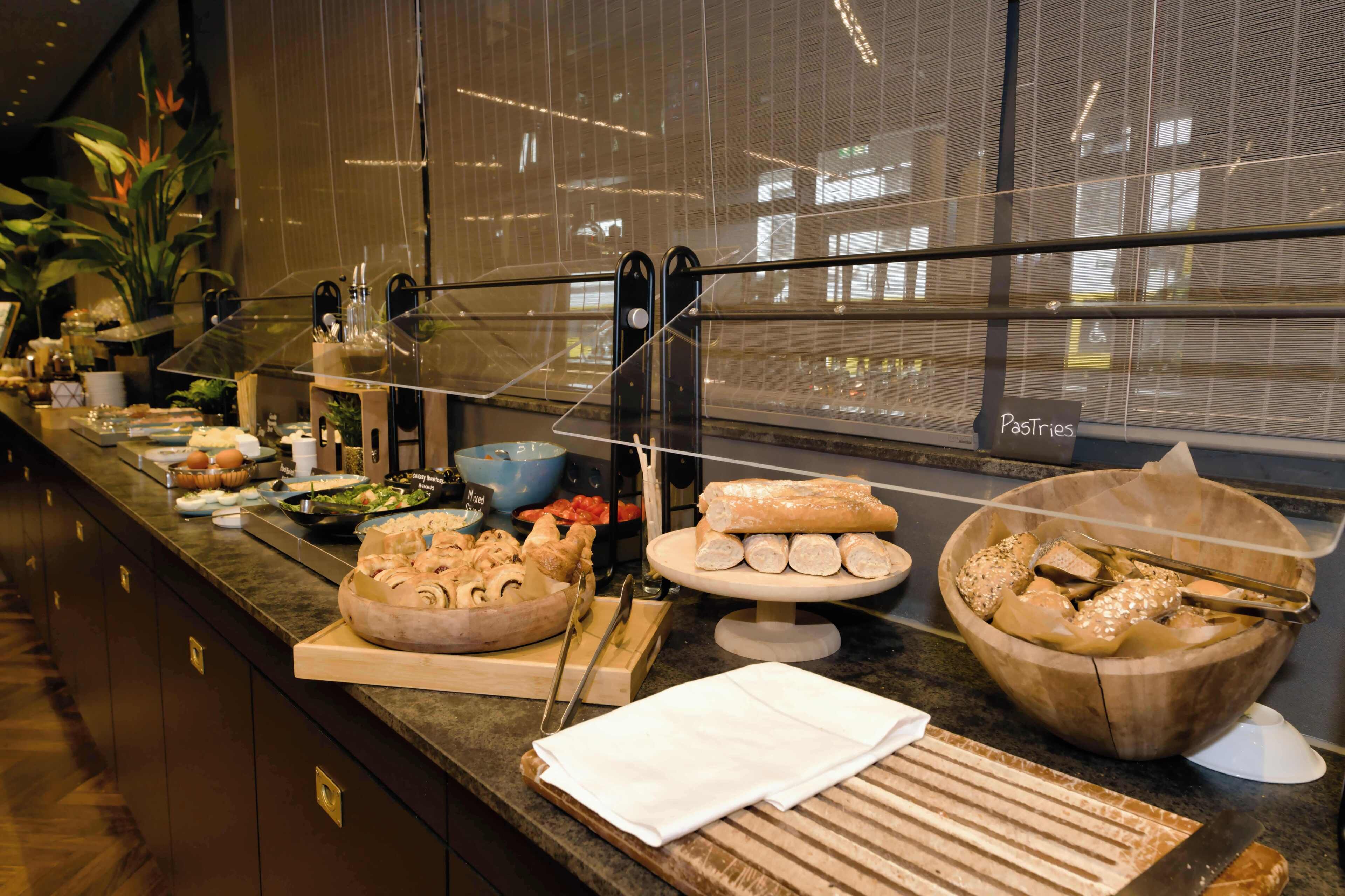 A buffet with various food items, a cutting board, and a sign labeled 'Pastries'.