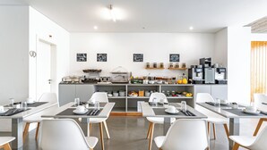 Una cocina moderna con electrodomésticos blancos, una cafetera y diversos alimentos en estantes.
