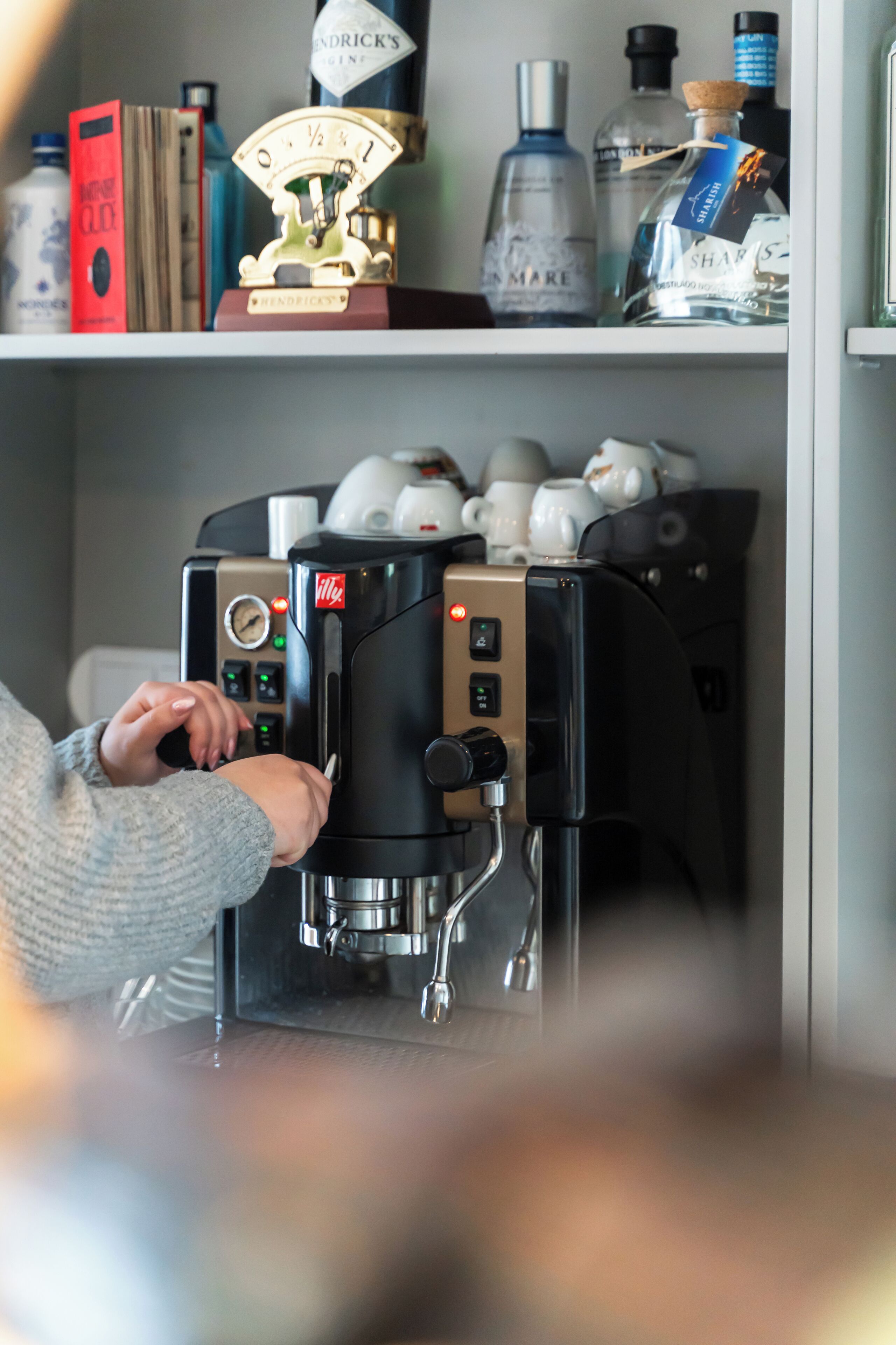 A coffee machine with a digital display and buttons, a scale, and a coffee pot on a counter.