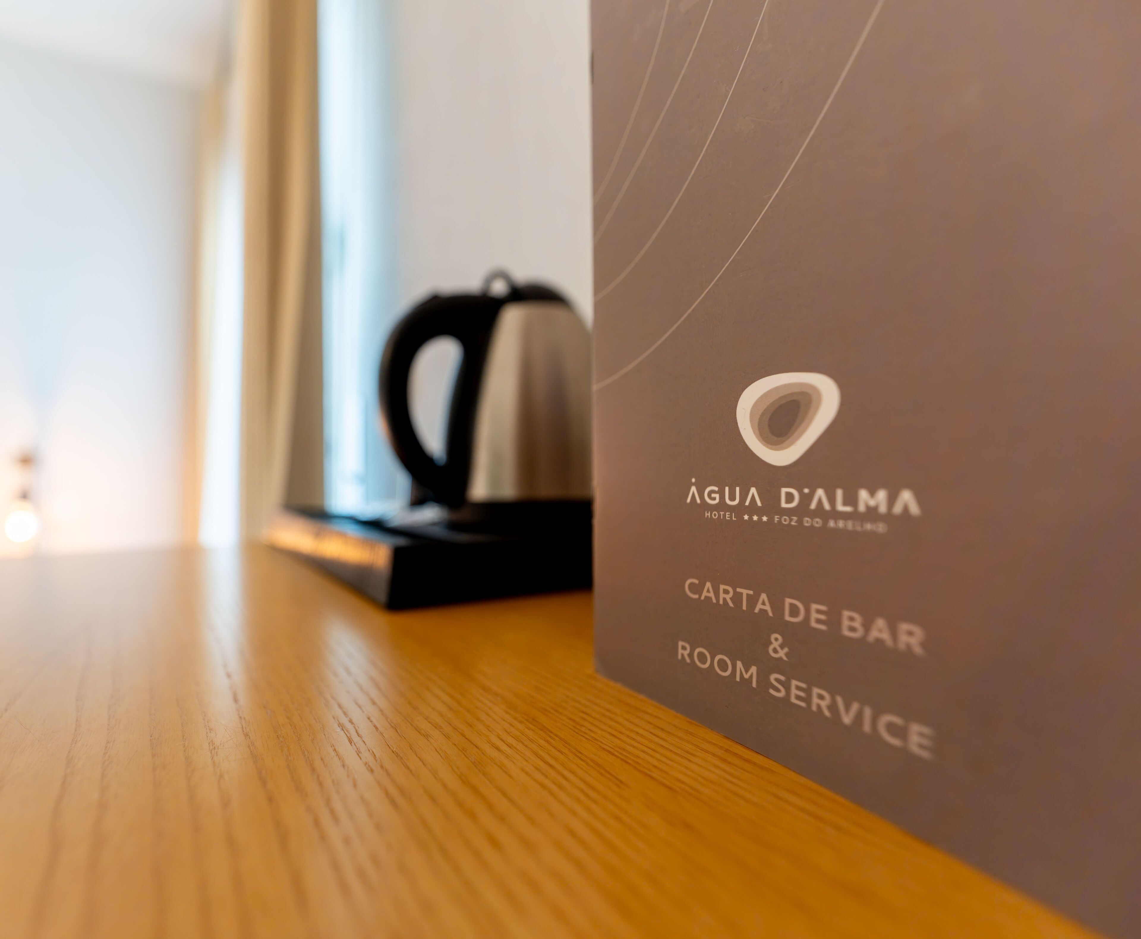 Een detailopname van een hotel servicekaart voor Água d'Alma Hotel, met vermelding van de bar en roomservice.
