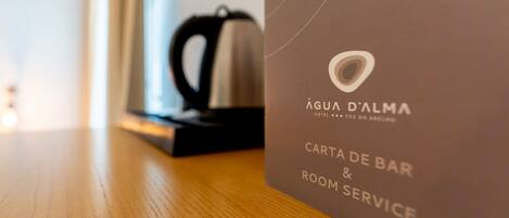 Een detailopname van een hotel servicekaart voor Água d'Alma Hotel, met vermelding van de bar en roomservice.