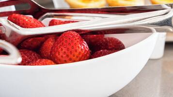 Un bufé con una variedad de alimentos, incluyendo fresas, pasteles y un pastel.