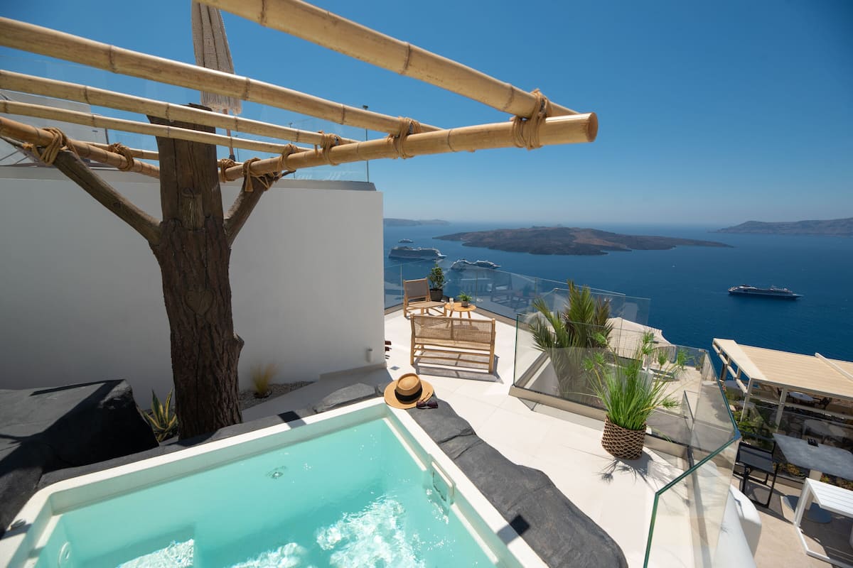 A rooftop pool with a view of the sea, a bamboo pergola, and outdoor seating.