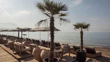 Playa privada, camas de playa (con cargo), camastros y sombrillas