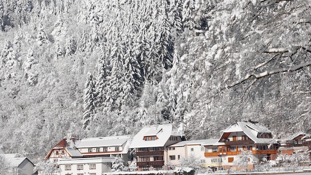 A snow-covered mountain with a row of traditional wooden buildings with sloped roofs, likely a ski resort or mountain lodge. - Ferienwohnung am Rain (Winden im Elztal)