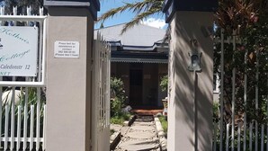 Una entrada cerrada a una propiedad llamada Kothuis Cottage en Caledonstr 12.
