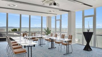 A conference room with a large table, chairs, and a view of the marina through large windows.