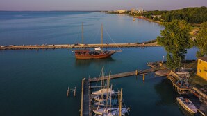 A harbor with a large boat docked at the pier, surrounded by calm water and a clear sky.