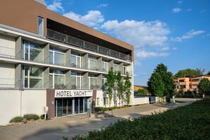 A hotel with a modern design, featuring a prominent sign for 'HOTEL YACHT'.