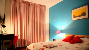 Un dormitorio con cama, escritorio y silla.