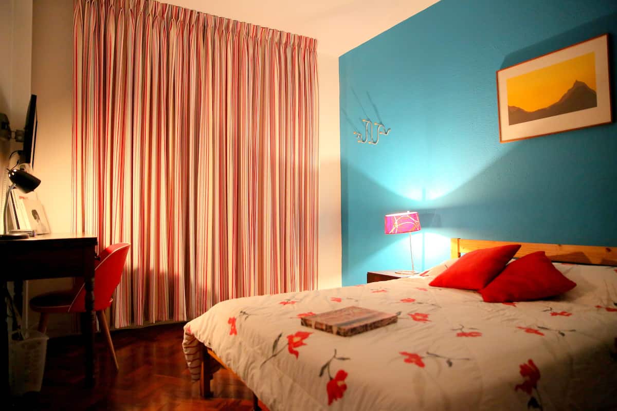 Un dormitorio con cama, escritorio y silla.