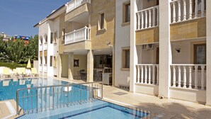 A hotel with a swimming pool, multiple balconies, and a terrace area. - Dinara Hotel (Kemer)