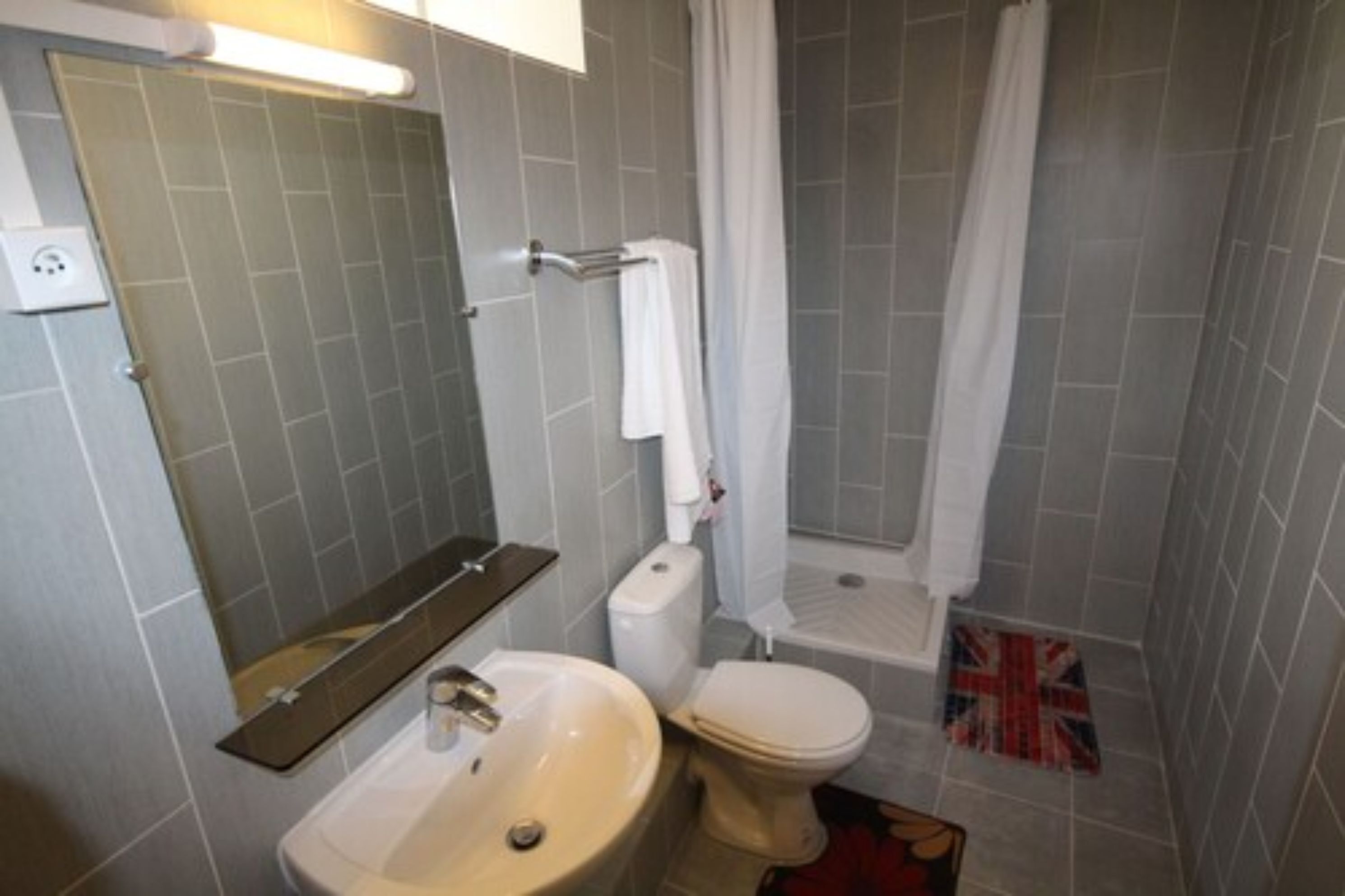 A bathroom with a sink, toilet, and shower.