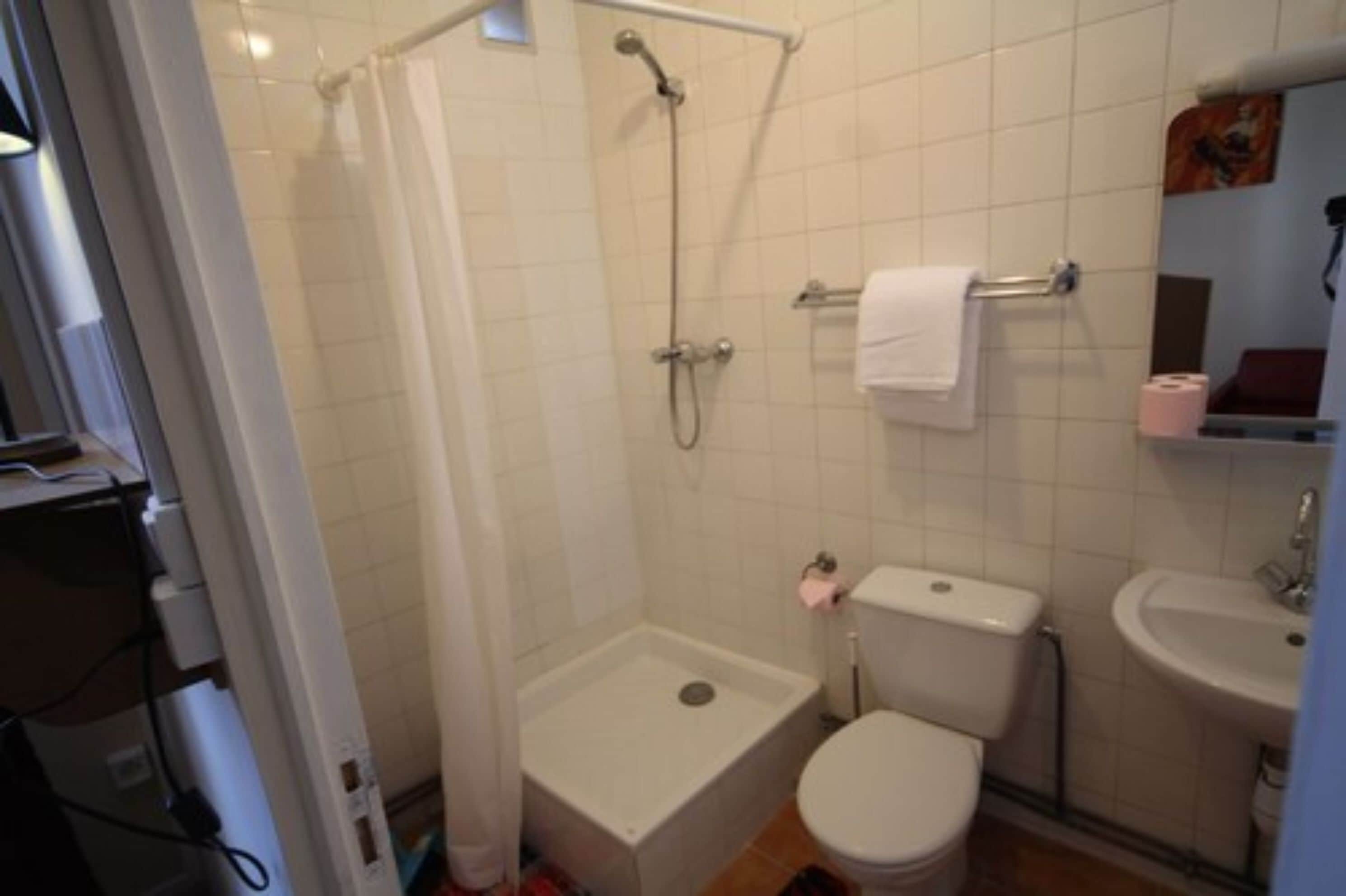 A bathroom with a shower, toilet, and sink.