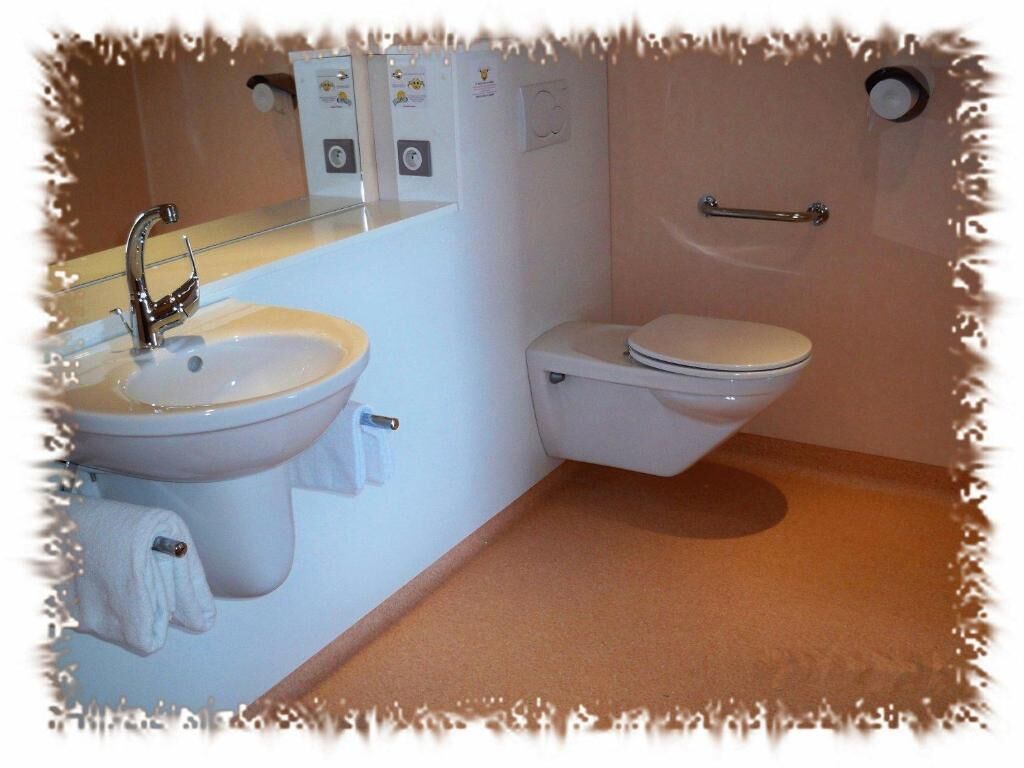 Ein Badezimmer mit Waschbecken, Toilette und Handtuchhalter.