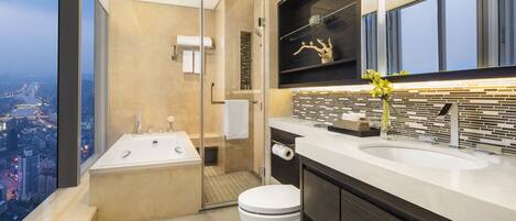 Ein modernes Badezimmer mit Badewanne, Toilette und Waschbecken. Es verfügt über ein großes Fenster mit Blick auf die Stadt.