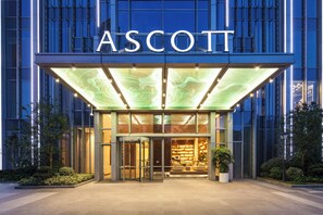 A hotel entrance with a glass facade, a rotating door, and a well-lit interior visible through the glass. - Ascott Central Wuxi (Wuxi)