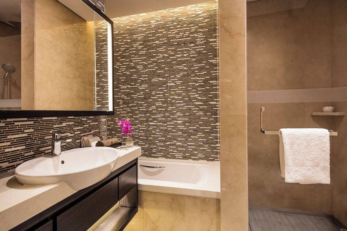 Un baño moderno con un lavamanos grande, una bañera y un espejo.