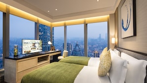 A modern hotel room with a large bed, a desk with a TV, and a city view. - Ascott Central Wuxi (Wuxi)
