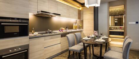 Una cocina moderna con electrodomésticos integrados, un comedor con mesa y sillas, y una atmósfera luminosa.
