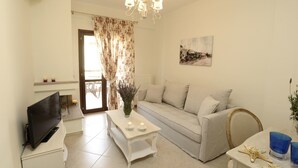 Una sala de estar con sofá, televisor, mesa con velas y candelabro.