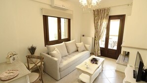Una sala de estar moderna con un sofá, una mesa de centro, una mesa de comedor y un televisor.
