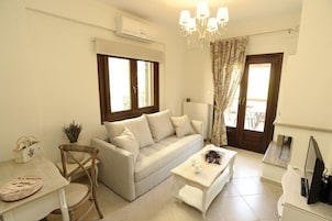 A modern living room with a sofa, a coffee table, a dining table, and a TV.