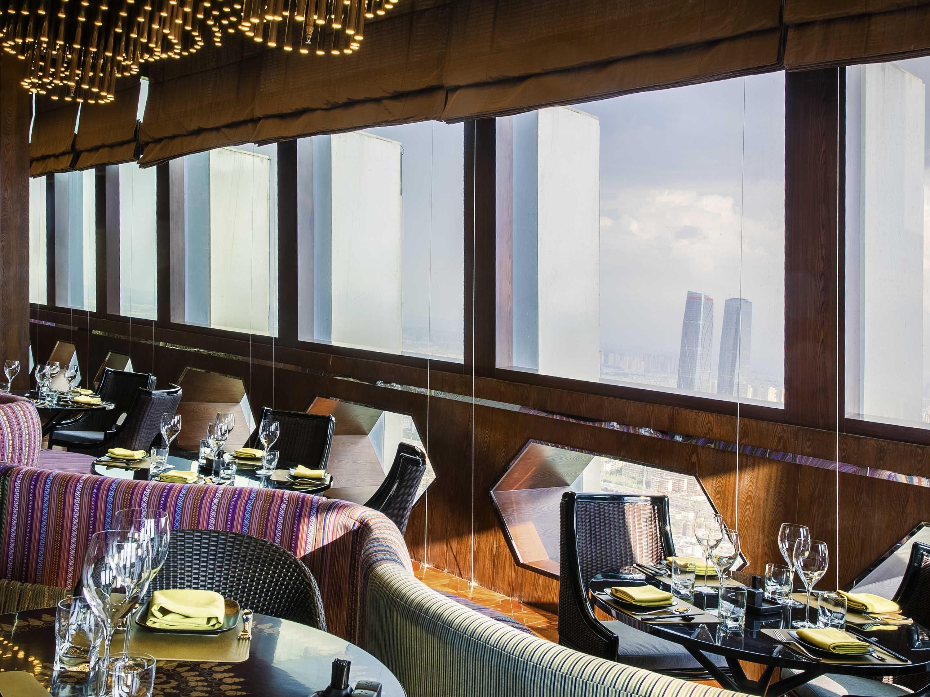 Un ristorante con soffitti alti, ampie finestre e arredamento moderno.