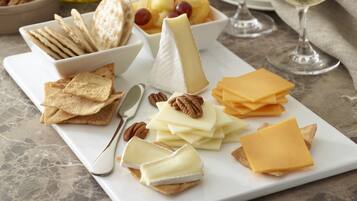 A cheese board with crackers, nuts, and fruits.
