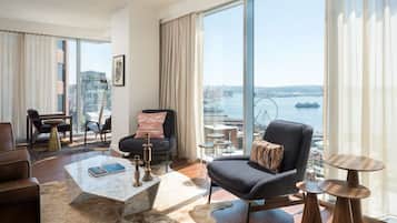 A modern living room with a large window offering a city view, a comfortable sofa, a coffee table, and a small side table.