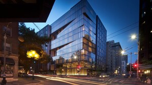 A modern building with a glass facade, located at a city intersection. - Thompson Seattle, by Hyatt (Seattle)
