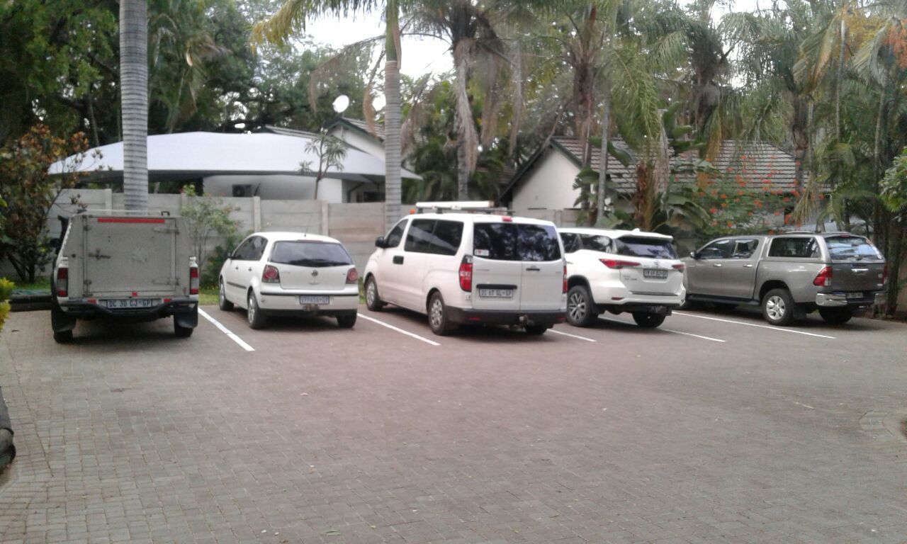 Un estacionamiento con varios autos y un camión.
