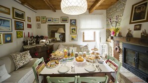 A dining area with a wooden table set for a meal, surrounded by chairs. - B&B Villa Filetta (Roccafluvione)
