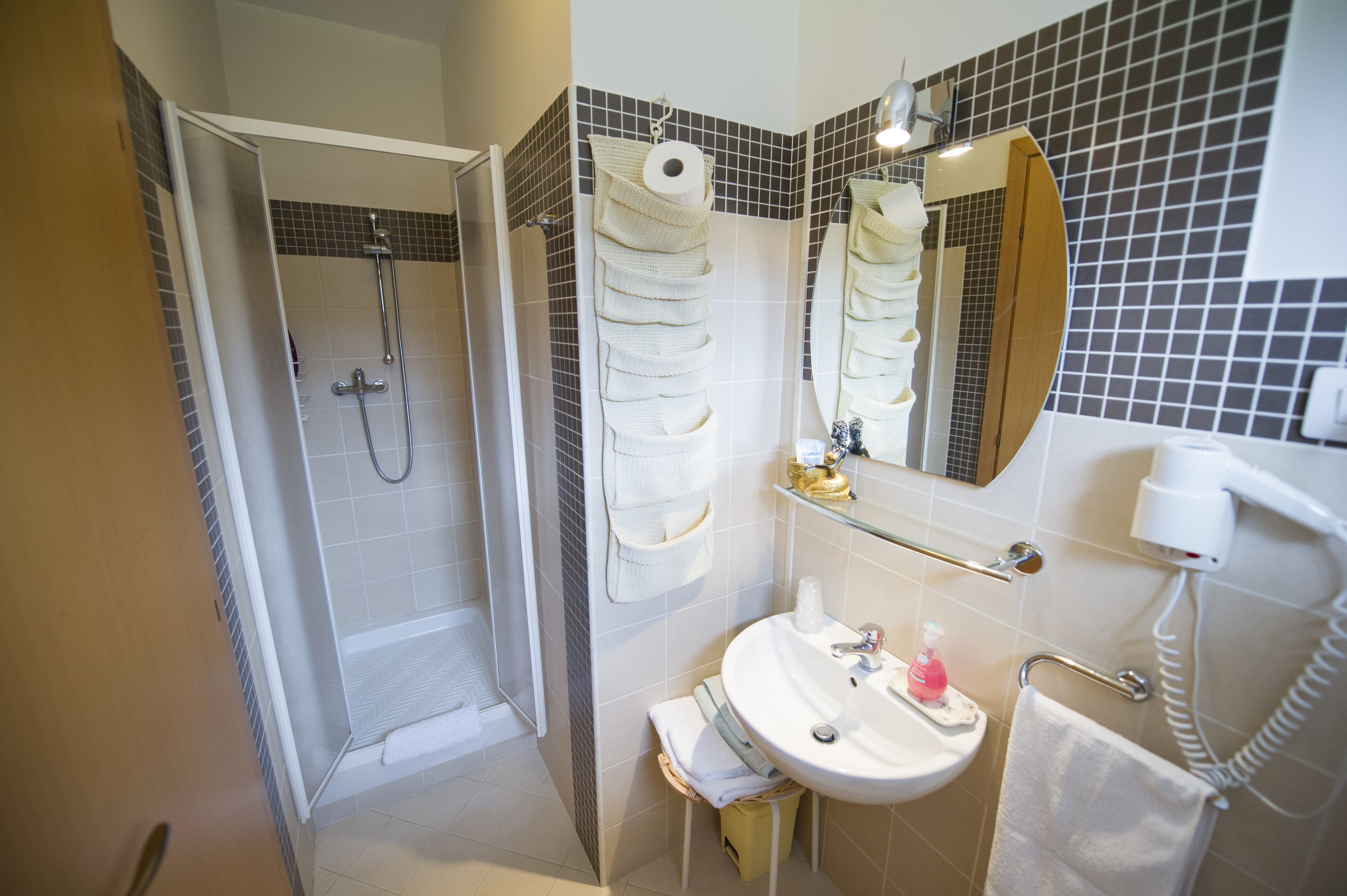 Baño con ducha, lavamanos y espejo.