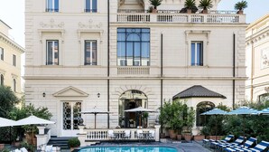 A multi-story hotel with a pool area, outdoor seating, and a garden. - Palazzo Dama (Rome)