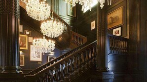 A grand lobby with a large chandelier, a staircase, and seating areas. - Palazzo Dama (Rome)