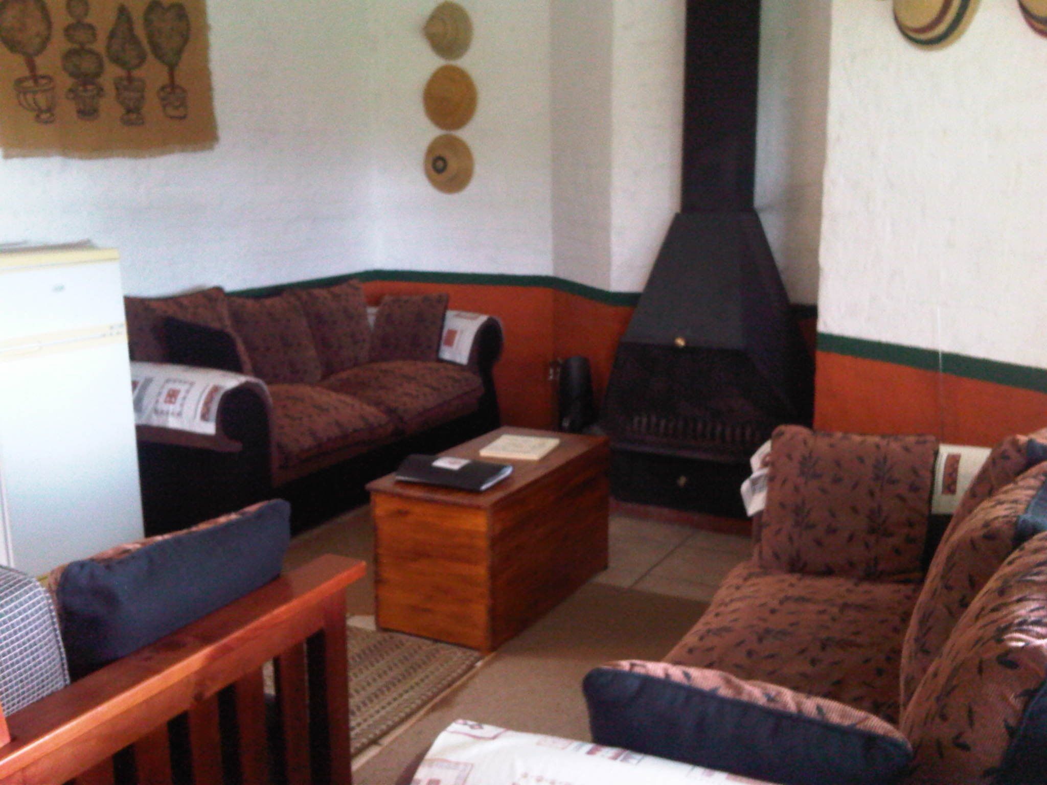Una sala de estar con sofá, sillón y chimenea.