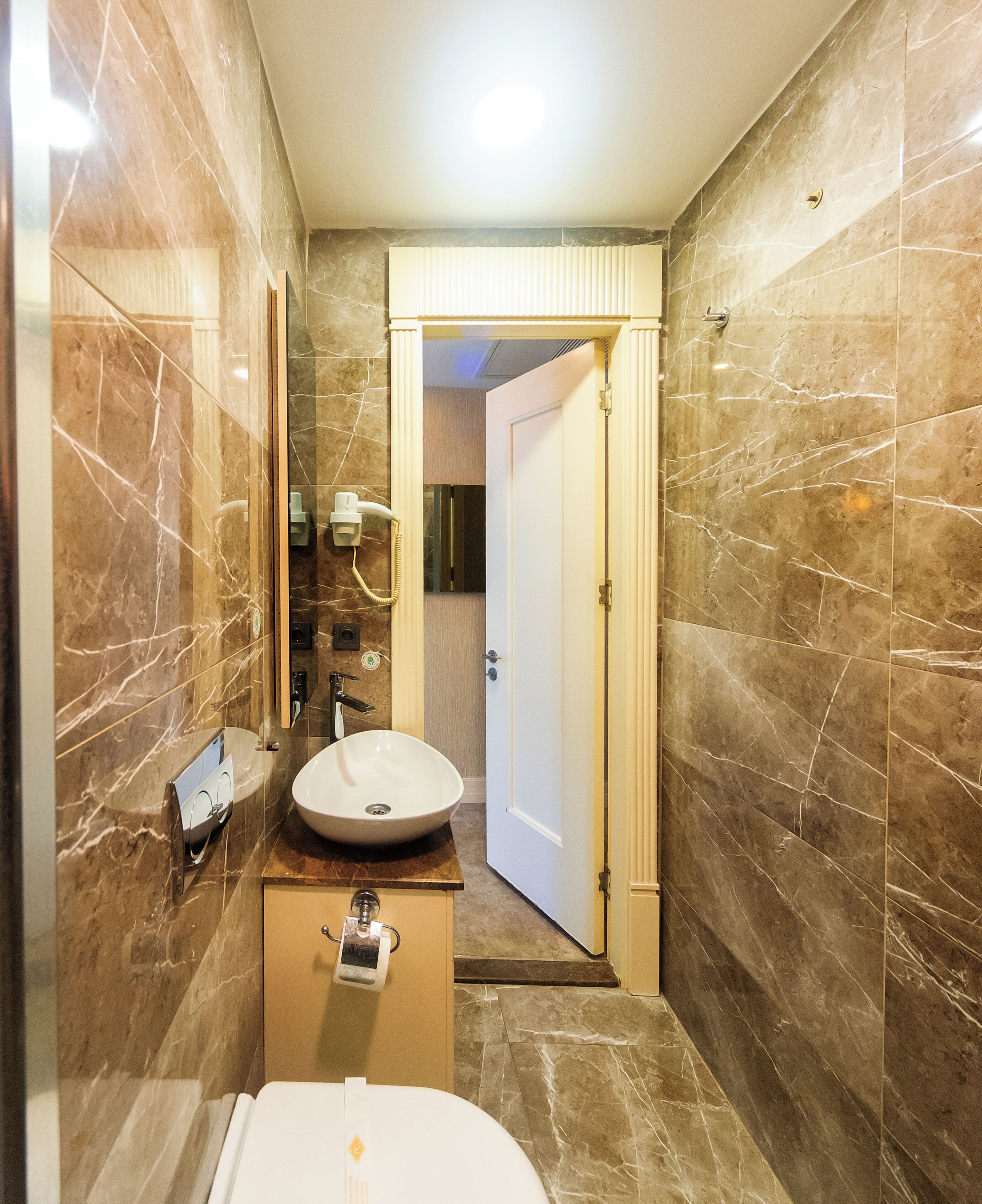 A bathroom with a sink, mirror, and toilet.
