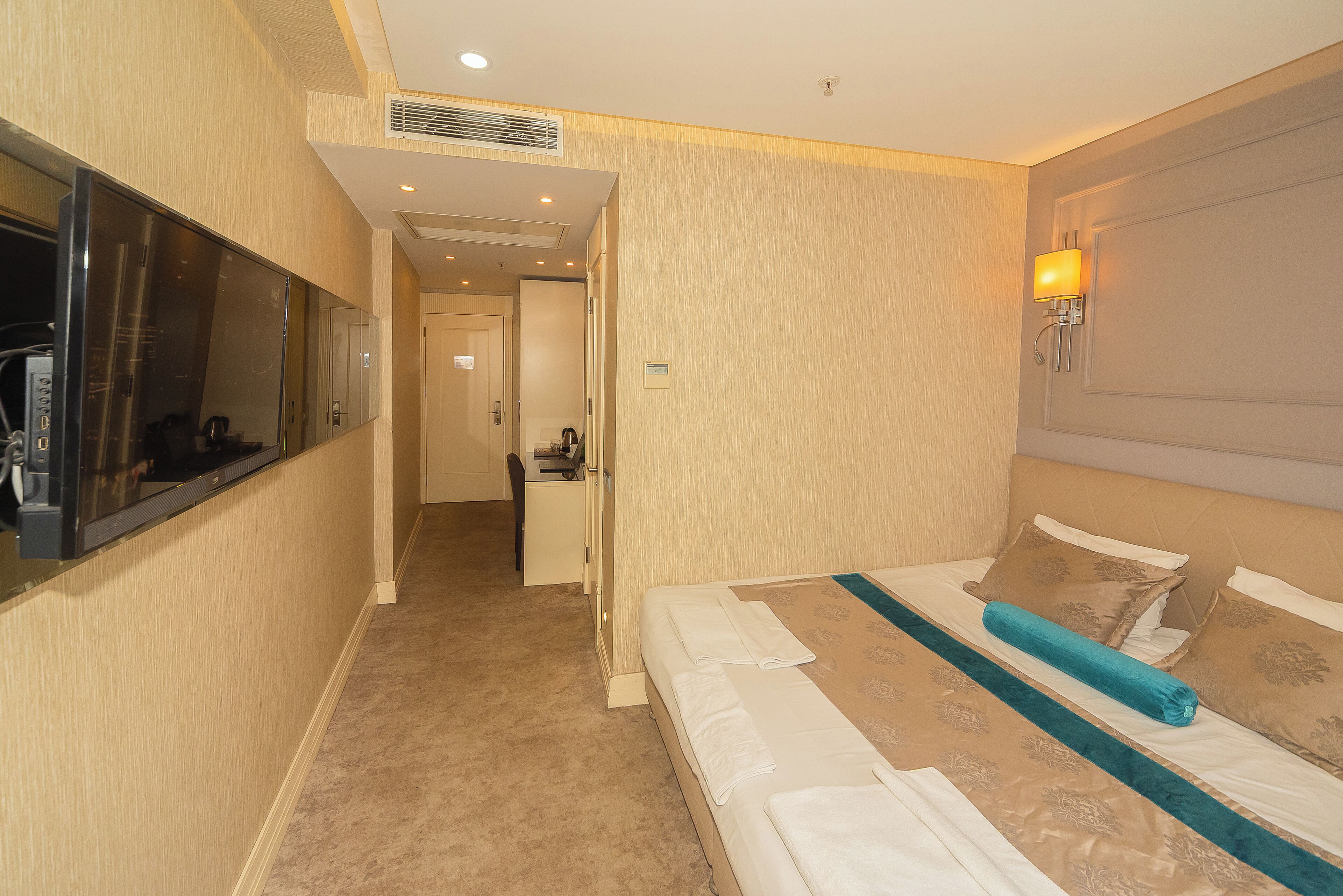 Una habitación de hotel con cama, televisión, escritorio y baño.
