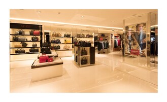 Una tienda de lujo con varias marcas, como FURLA, ARMANI JEANS y CALVIN KLEIN.