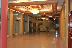Un hall d’entrée spacieux, doté d’un sol ciré, d’un magnifique lustre et d’un escalier menant aux étages supérieurs.