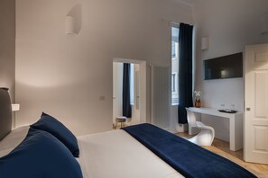 Relax in a spacious room with a large bed, flat-screen TV, and comfortable chair.
