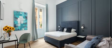 Un dormitorio moderno con cama, sofá, escritorio y un cuadro.