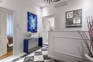 Stunning hallway with a console table, globe, and decorative wall art, leading to a door.