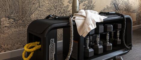 A gym area with exercise equipment, a water bottle, and a pair of shoes.