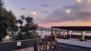 A rooftop pool with a view of mountains and a sunset. - Galagos Lodge (Hartbeespoort)