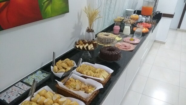 A buffet with various baked goods and beverages. - Master Hotel (Balneário Camboriú)
